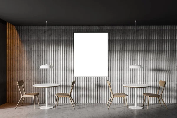 Interior of minimalistic loft cafe with grey walls, concrete floor, round tables with wooden chairs and vertical mock up poster frame. 3d rendering