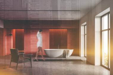 Lüks banyoda turuncu ve beyaz duvarları, beton zemini, rahat bir küveti ve koltuğu olan bulanık genç bir kadın. Spa konsepti. Renkli resim çift pozlama