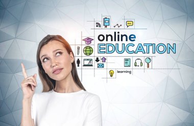 Avrupalı genç bir kadın renkli online eğitim simgeleriyle gri duvarın yanında dikiliyor. Coronavirüs sırasında öğrenme kavramı. Covid 19 salgın ve parlak fikir.