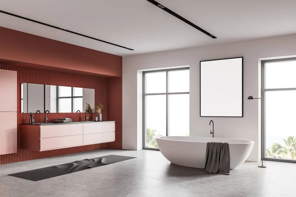 Corner of luxury bathroom with white and orange walls, concrete floor, comfortable bathtub with vertical mock up poster above it, double sink and windows with blurry tropical view. 3d rendering