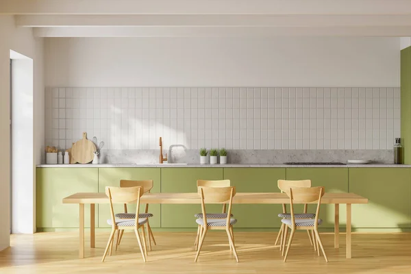 Interior of modern kitchen with white walls, green countertops and cupboards and wooden dining table with chairs. 3d rendering