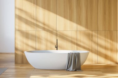 Minimalist banyo, beyaz ve ahşap duvarlar, ahşap zemin ve üzerinde havlu asılı rahat beyaz küvet. 3d oluşturma