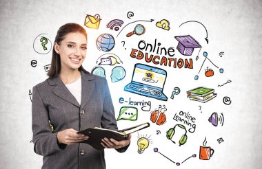 Üzerinde yaratıcı ve renkli çevrimiçi eğitim çizimi olan cocnnet duvarının yanında duran neşeli genç iş kadını.