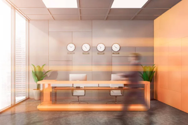 タイムゾーンクロック グレーとオレンジの壁とコンクリート床とオレンジの受付デスクを通過若いビジネスマンをブリュリー 国際的な企業理念 トーン画像 — ストック写真