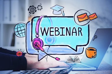 Bulanık masada dizüstü bilgisayarda renkli Webinar çizimi olan bir adamın elleri. Tonu ayarlanmış resim