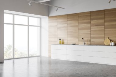 Modern mutfağın köşesinde ahşap duvarlar, beton zemin ve lavabo ve fırında yapılmış beyaz tezgahlar var. Bulanık tropikal manzaralı bir pencere. 3d oluşturma