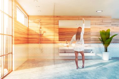 Panoramik banyoda tahta ve beyaz tuğlalı duvarları olan genç bir kadın ayna ve duş kabiniyle rahat bir çift lavabo. Bulanık şehir manzarası. Tonu ayarlanmış resim