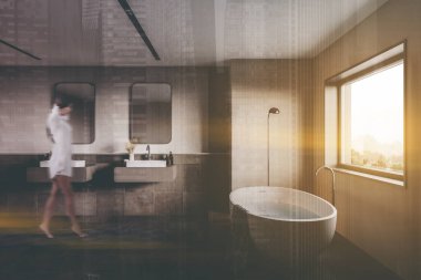 Bulanık genç bir kadın bej ve fayanslı duvarları, rahat küveti ve iki aynalı çift lavabosu olan şık bir banyoda yürüyor. Renkli resim çift pozlama