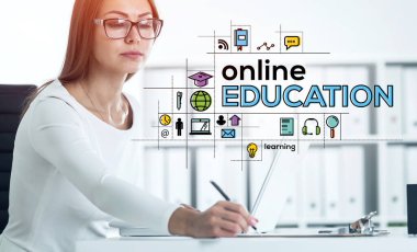 Gözlüklü Avrupalı bir kadın bulanık masada dizüstü bilgisayarla notlar alıyor. Çevrimiçi parlak eğitim ikonlarına iki kez maruz kalmak. Coronavirus covid 19 salgını sırasında öğrenme kavramı. Tonu ayarlanmış resim