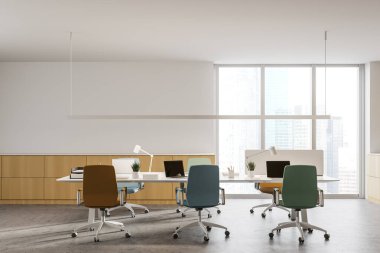 Panoramik açık uzay ofisinin içinde beyaz ve ahşap duvarlar, beton zemin, bilgisayarlı uzun masa ve renkli sandalyeler ve bulanık şehir manzaralı pencere. 3d oluşturma