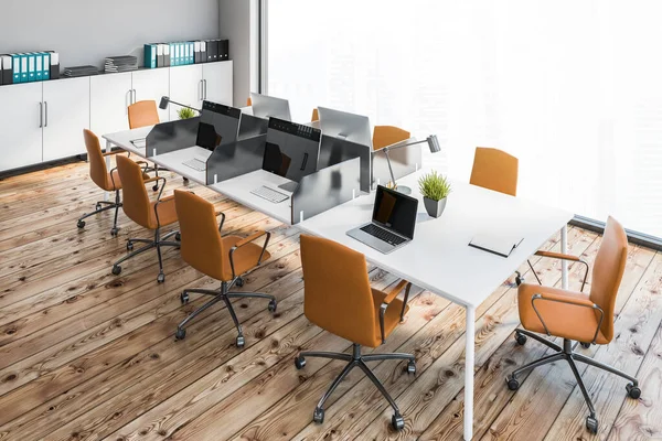 Top view of open space office with gray walls, wooden floor, big white computer table with orange chairs and white file cabinets. Panoramic window with blurry cityscape. 3d rendering