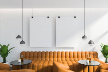 Beyaz duvarları, rahat turuncu kanepesi ve yuvarlak masaların yanında duran koltukları ve iki dikey maket posteriyle şık restoranın ön manzarası. 3d oluşturma