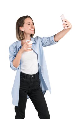 Sıradan kıyafetlerle sohbet eden ya da akıllı telefonuyla selfie çeken genç Avrupalı bir kadının izole portresi. İletişim ve sosyal medya kavramı