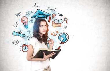 Üzerinde renkli bir çizim olan beton duvarın yanında duran not defteri ve kalemle düşünceli genç bir kadın. Bilgi kavramı. Model