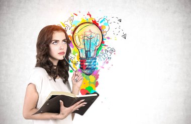 Dalgalı siyah saçlı ve defterli düşünceli genç bir kadın renkli iş fikri çizimiyle beton duvarın yanında duruyor. Planlama ve iş stratejisi kavramı. Model