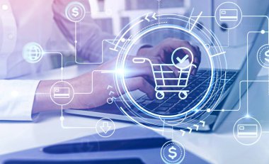 Bulanık odada dizüstü bilgisayar kullanan tanınmayan genç bir iş kadınının elleri. Çevrimiçi HUD alışveriş arayüzü iki katına çıkıyor. E- ticaret anlayışı. Tonu ayarlanmış resim