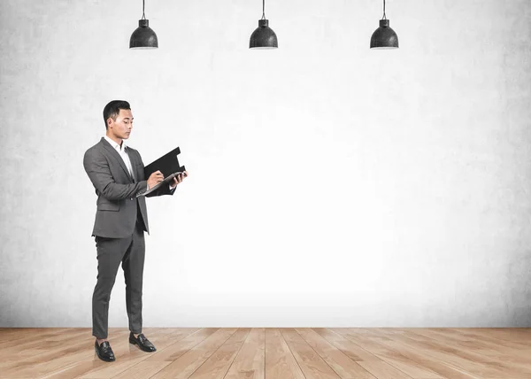 Full Length Portrait Serious Young Asian Businessman Writing Clipboard Concrete — Stock Photo, Image