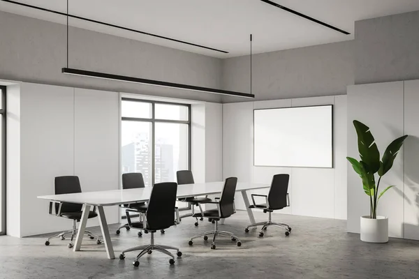 Corner of modern meeting room with white and concrete walls, long white conference table with black armchairs, horizontal mock up poster frame and window with blurry cityscape. 3d rendering