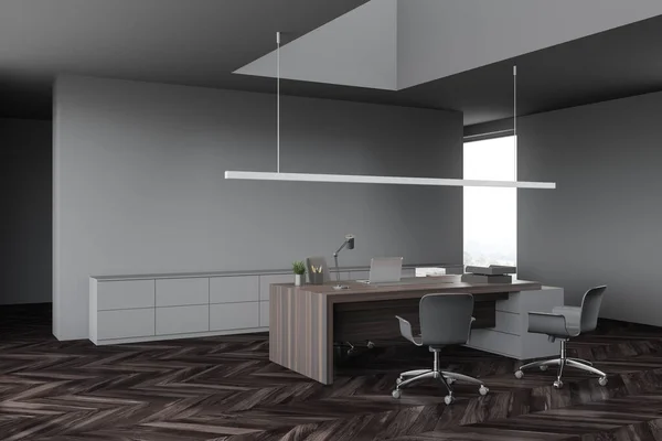 Corner of modern CEO office with gray walls, dark wooden floor and computer table with chairs for visitors. 3d rendering