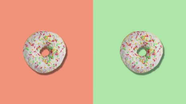 Two rotating donuts on orange and green screen divided into two parts. — Stock Video