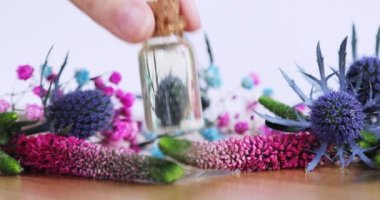 Parfüm üreticisi yeni aroma sıvısı yaratıyor ve masaya gerekli yağı koyuyor..