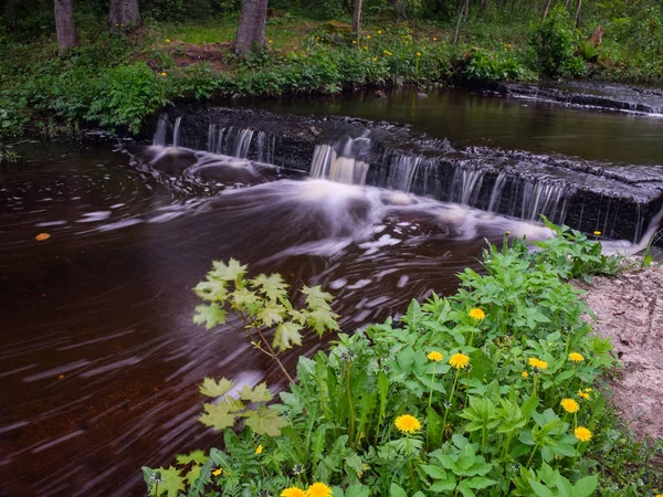Nehirde hareket bulanıklığı olan küçük şelaleli (çağlayan) manzara. 
