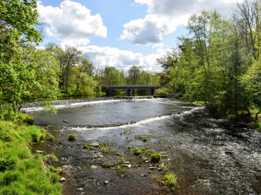Nehirde hareket bulanıklığı olan küçük şelaleli (çağlayan) manzara.