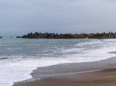 Huzurlu Kuzey Denizi manzarası Küçük dalgalar ve taş iskele