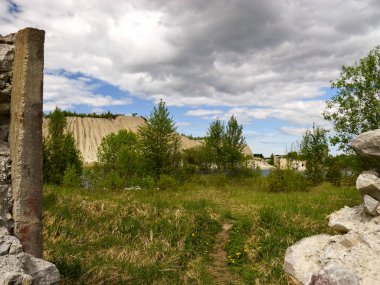 Beyaz bir dağın ve yeşil ağaçların üzerinden geçen taş bir çitin ötesine bak.