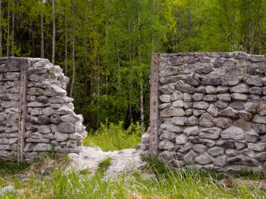 Beyaz bir dağın ve yeşil ağaçların üzerinden geçen taş bir çitin ötesine bak.