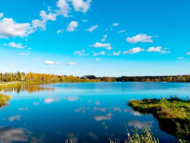 Göl kenarındaki renkli sonbahar manzarası, altın sonbahar, renkli ağaçlar ve yansımalar.