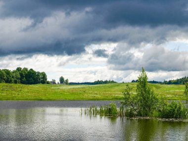 Gök gürültülü ve ağaçlı bir manzara.