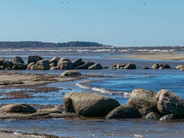  Kayalık deniz kıyıları, gökyüzünde beyaz bulutlar