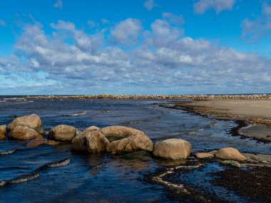  Kayalık deniz kıyıları, gökyüzünde beyaz bulutlar