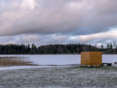 Göl kıyısında sarı soyunma odası olan manzara