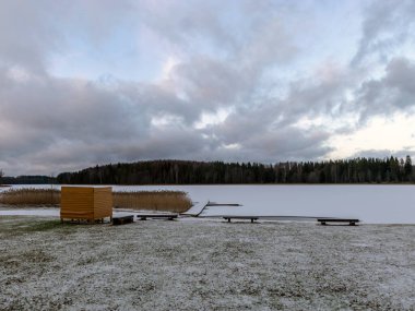 Göl kıyısında sarı soyunma odası olan manzara