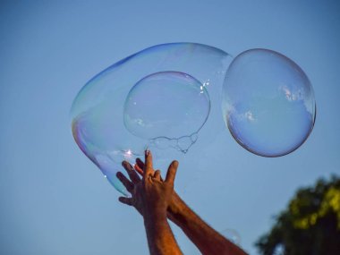 Mavi gökyüzüne karşı köpüklü sabun resmi