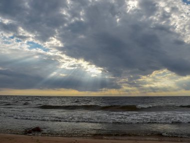 Sahilde güzel gün batımı manzarası, muhteşem gökyüzü ve denizin üzerindeki bulutlar.
