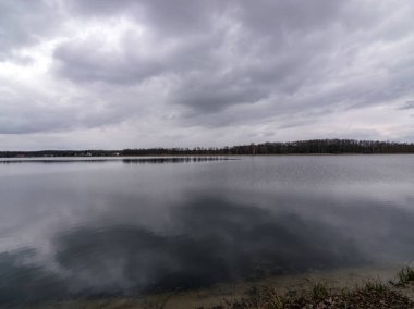 Sakin göl aynasının görüntüsü, sudaki bulutların parlaklığı.