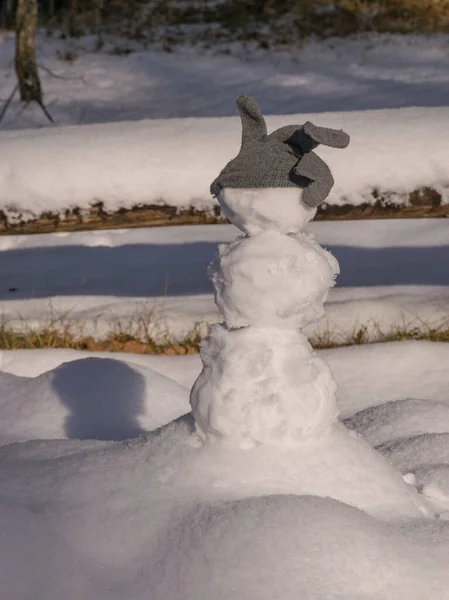 图片与白色雪人 灰色手套在头上 美丽的雪纹理和阴影 — 图库照片