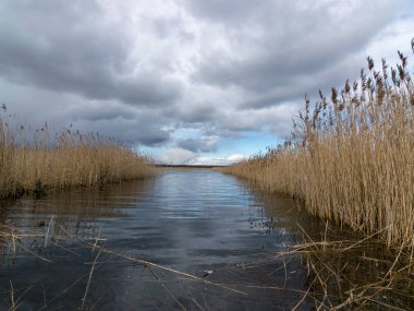 Göl ve gökyüzünün arka planda olduğu güzel manzara, ön planda bulanık su.