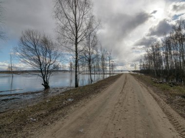 Baharda sular altında kalan bir göl manzarası, sahile giden yol suyla bitiyor.