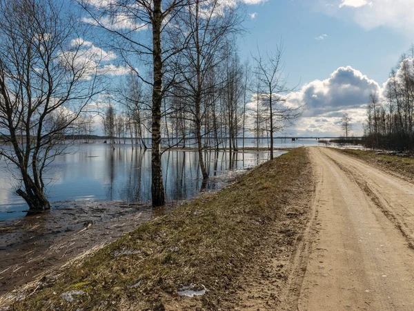 Baharda sular altında kalan bir göl manzarası, sahile giden yol suyla bitiyor.