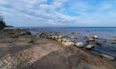 Güzel deniz manzarası, güzel bulutlar, bir sürü kaya. Deniz kenarında ilkbahar, Kaltene kıyısı, Letonya