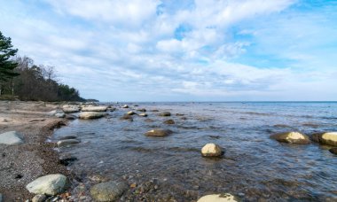 Güzel deniz manzarası, güzel bulutlar, bir sürü kaya. Deniz kenarında ilkbahar, Kaltene kıyısı, Letonya