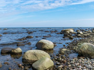 Güzel deniz manzarası, güzel bulutlar, bir sürü kaya. Deniz kenarında ilkbahar, Kaltene kıyısı, Letonya