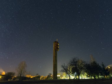 Yıldızlı gökyüzü ile gece manzarası, arka planda su kulesi silueti.
