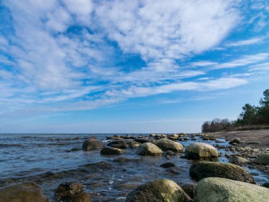 Güzel deniz manzarası, güzel bulutlar, bir sürü kaya. Deniz kenarında ilkbahar, Kaltene kıyısı, Letonya