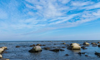 Güneşli bir günde birçok taşlı mavi deniz manzarası, Kaltene kıyısı, Letonya