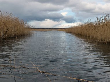 Göl ve gökyüzünün arka planda olduğu güzel manzara, ön planda bulanık su.